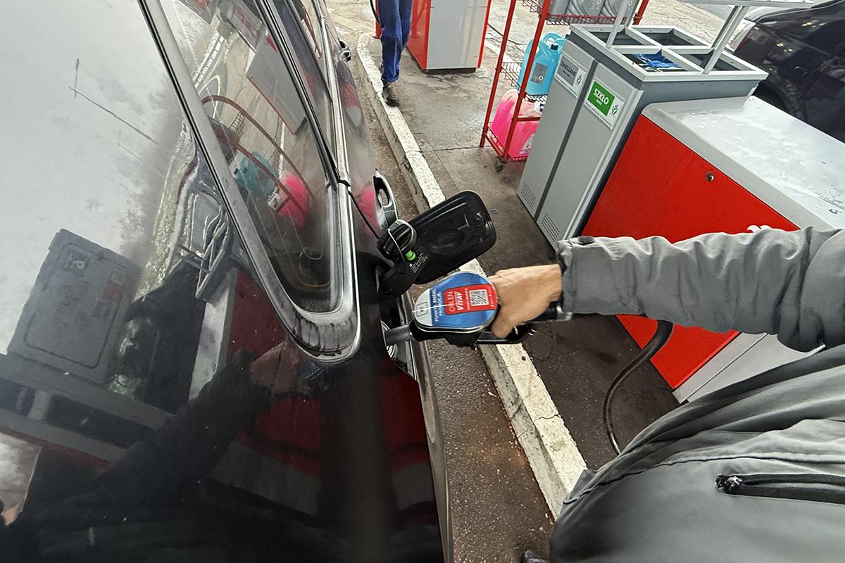 Мужчина заправляет автомобиль